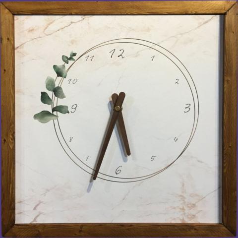 a framed clock with a botanical accent