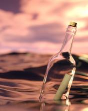 message in a glass bottle floating on the surface of the sea at dusk via Canva